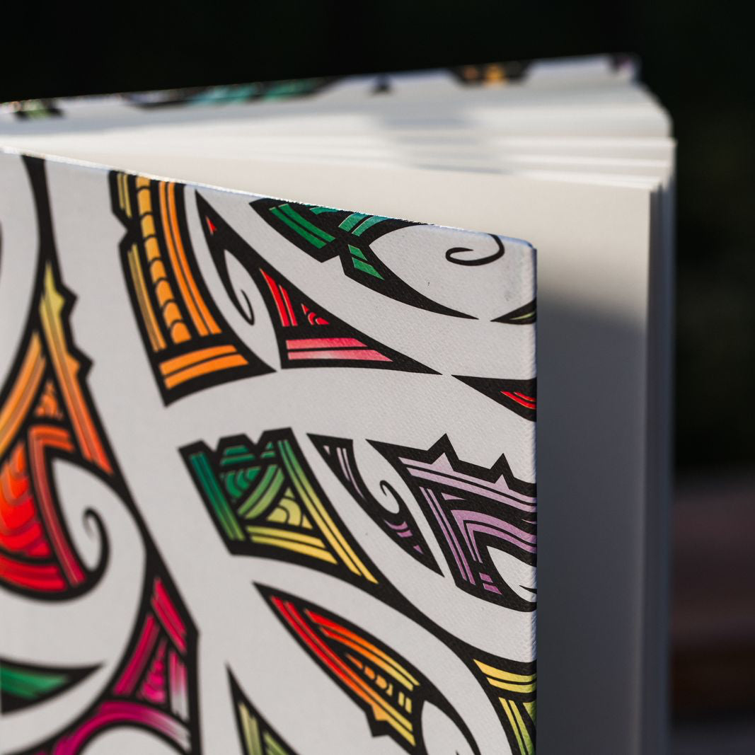 Colorful notebook design with intricate Maori patterns on a white background