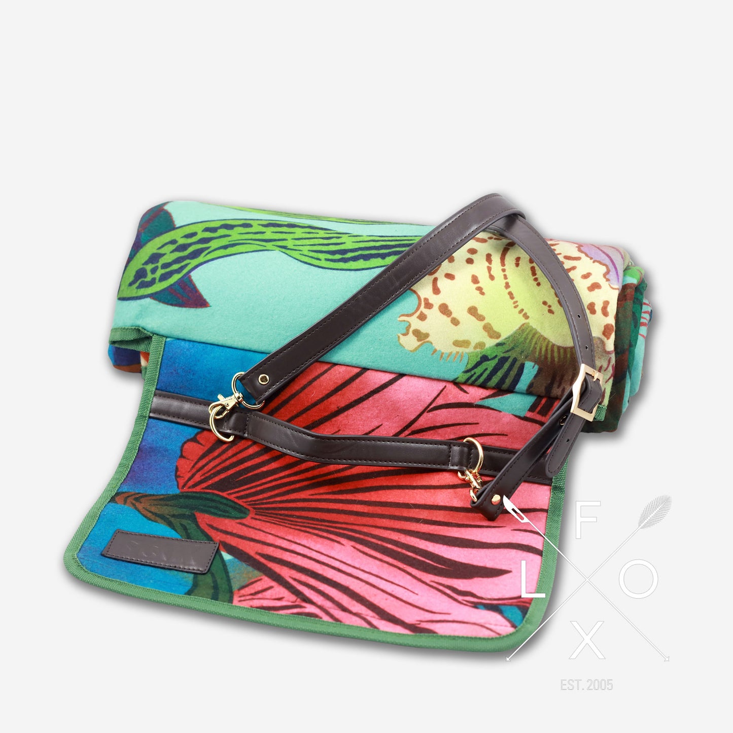 Colourful picnic blanket rolled up with straps.