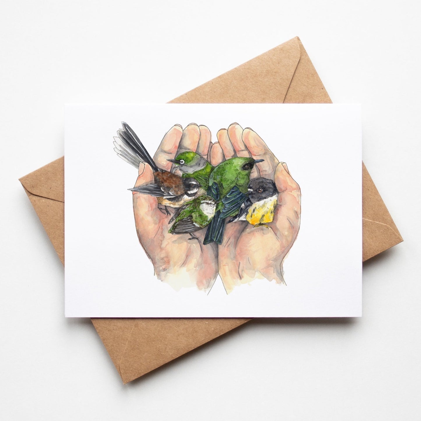 Greeting card by Leah Ingram Artist featuring 2 hands holding 5 small New Zealand native birds.