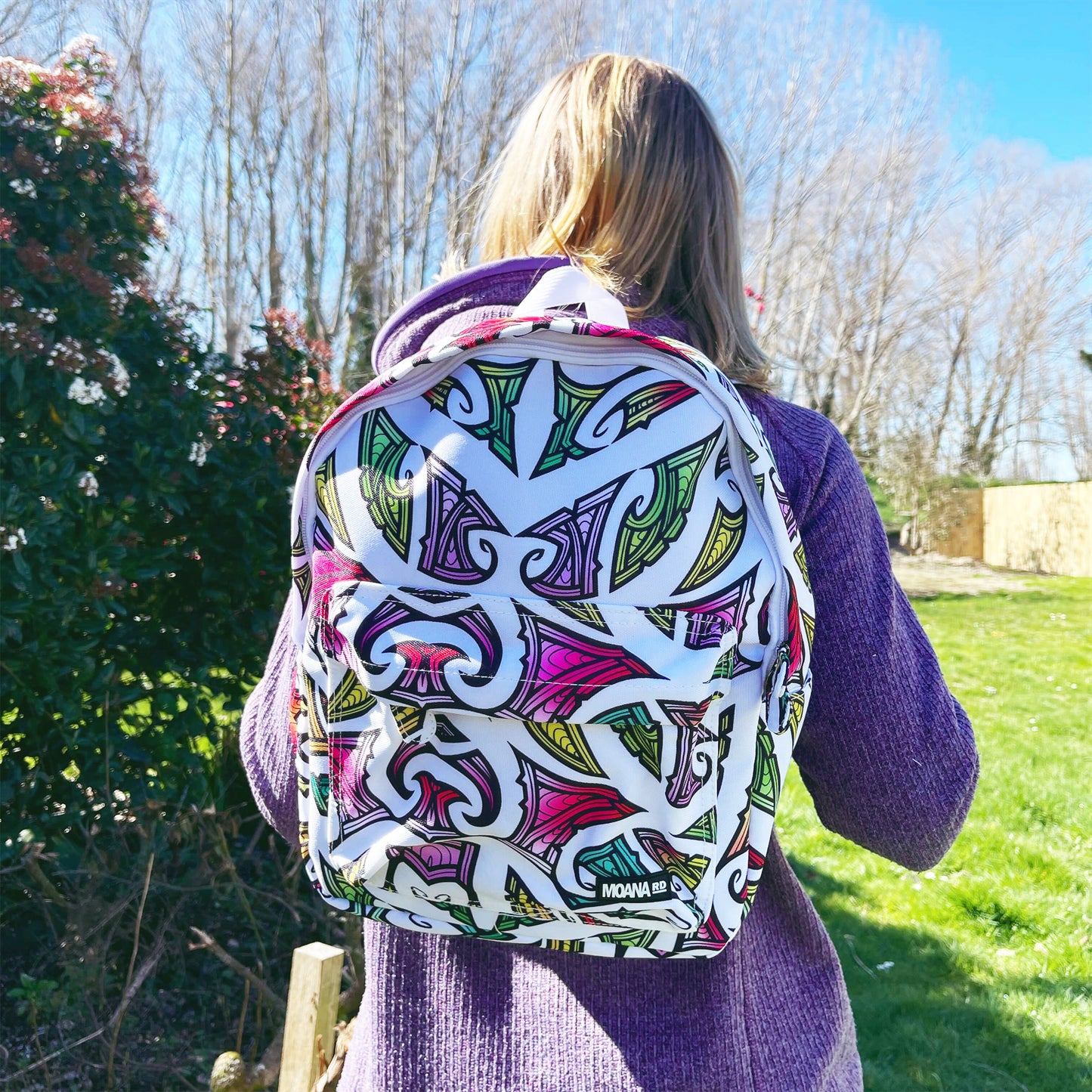 Teenager wearing a Kids backpack in white with colourful Maori design by Miriama Grace Smith.