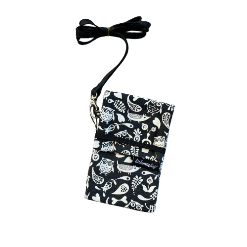 Black phone pouch bag with white floral, owl and dog print and black lanyard.