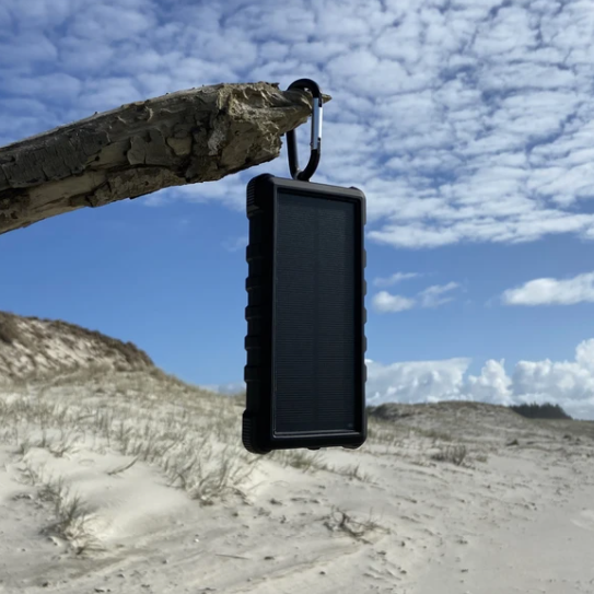 SunSaver 24K, 24,000mAh Solar Power Bank in the sun on the beach.