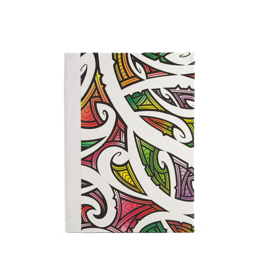 A notebook with a white cover featuring a vibrant, multicolored Maori tribal-inspired pattern of black lines and curved shapes in red, orange, yellow, green, and purple.