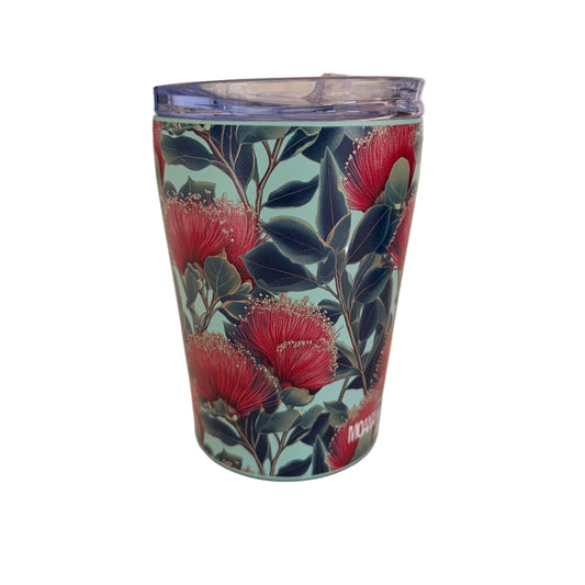 A slim insulated tumbler with a clear lid, featuring a botanical pattern of red pohutukawa flowers and dark green leaves on a light teal background.