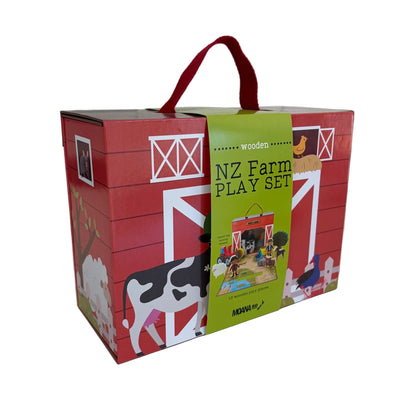 A red wooden toy box labeled 'NZ Farm PLAY SET' with a green front panel, shown on a white tabletop. The box features farm illustrations including a cow, barn, chicken, and tractor, plus a red carrying handle.