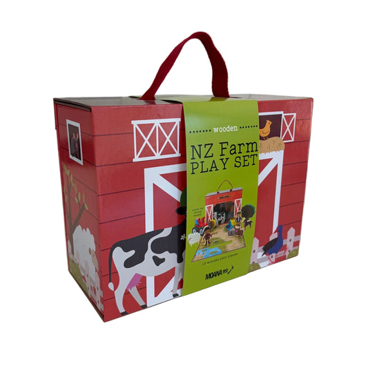 A red wooden toy box labeled 'NZ Farm PLAY SET' with a green front panel, shown on a white tabletop. The box features farm illustrations including a cow, barn, chicken, and tractor, plus a red carrying handle.