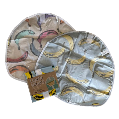 Two banana print lunch wraps showing the wipeable underside and a set packaged up alongside.