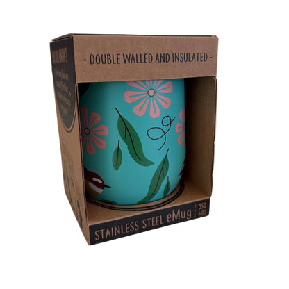 A turquoise stainless steel eMug with pink and green floral patterns and a fantail bird shown inside its brown cardboard packaging on a light countertop.