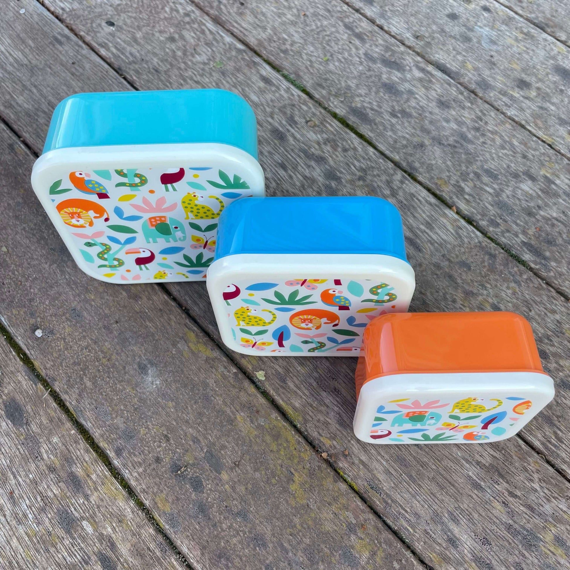 Trio of snack boxes in blue & orange  featuring jungle animals on the lids.