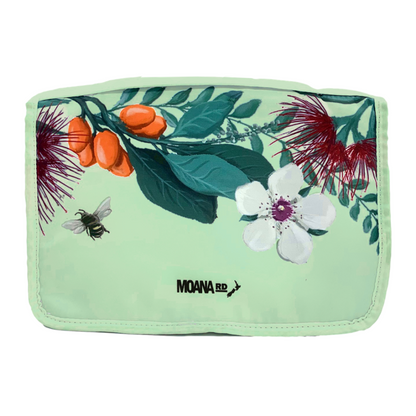 Pale green toiletry bag with New Zealand floral pattern at the top.