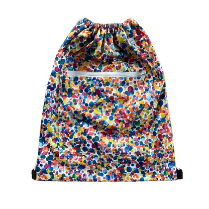 Drawstring backback style wetbag in mutlicoloured dot print and a zip pocket on the front.