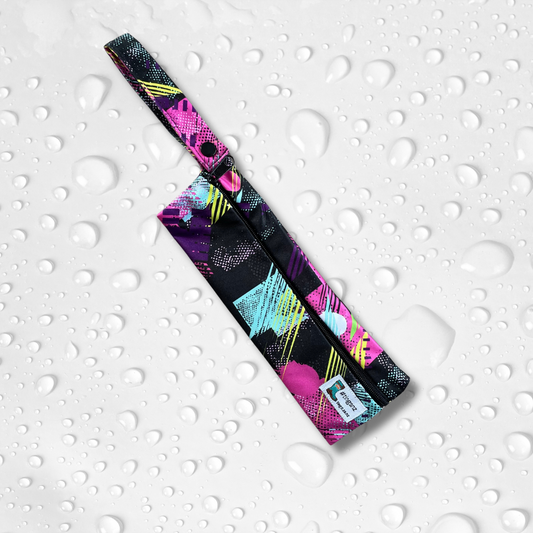 Small wetbag suitable for cutlery or toothbrushes in an abstract pink and black print.