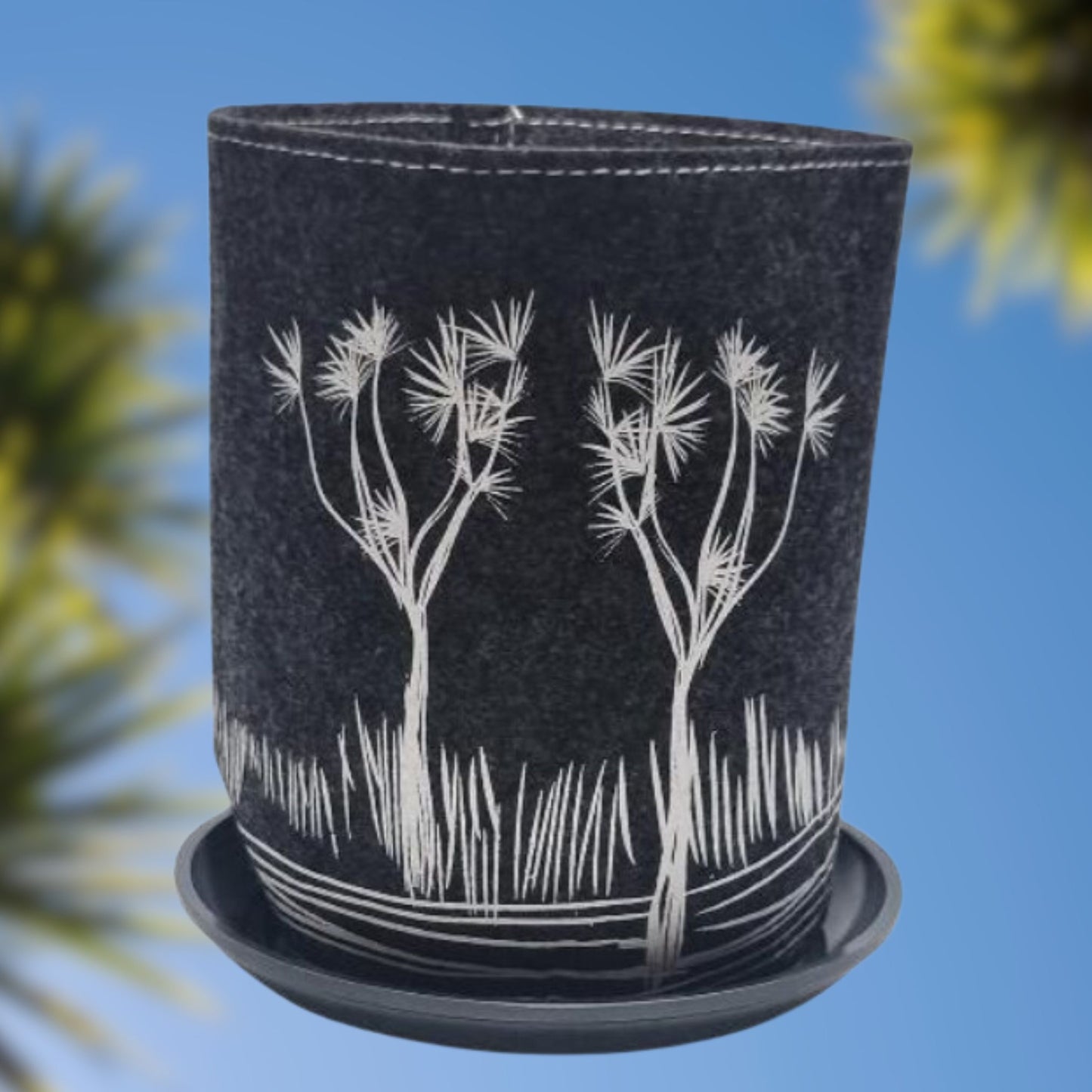 Felt plant bag with saucer in dark grey with white Cabbage tree print.