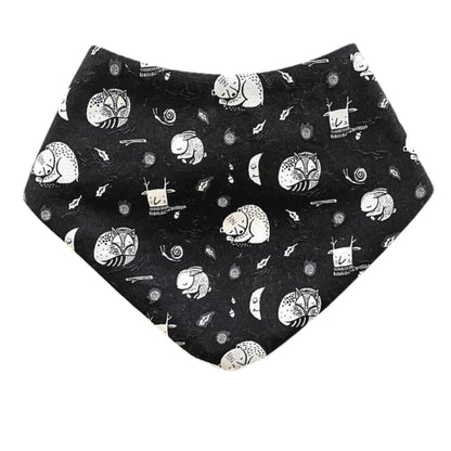 Baby dribble bib in black fabric with white sleeping bears, foxes and rabbits.