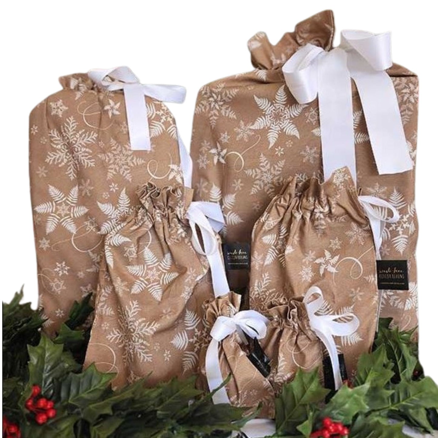 Reusable Christmas gift bags in beige with a white snowflake print and white satin ribbon.