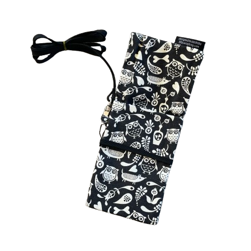 Black phone pouch bag with white floral, owl and dog print and black lanyard. Pouch is opened up to show the pocket.