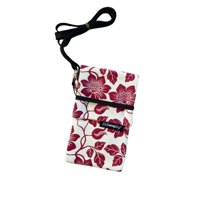 Cream phone pouch bag with red floral print and black lanyard. 