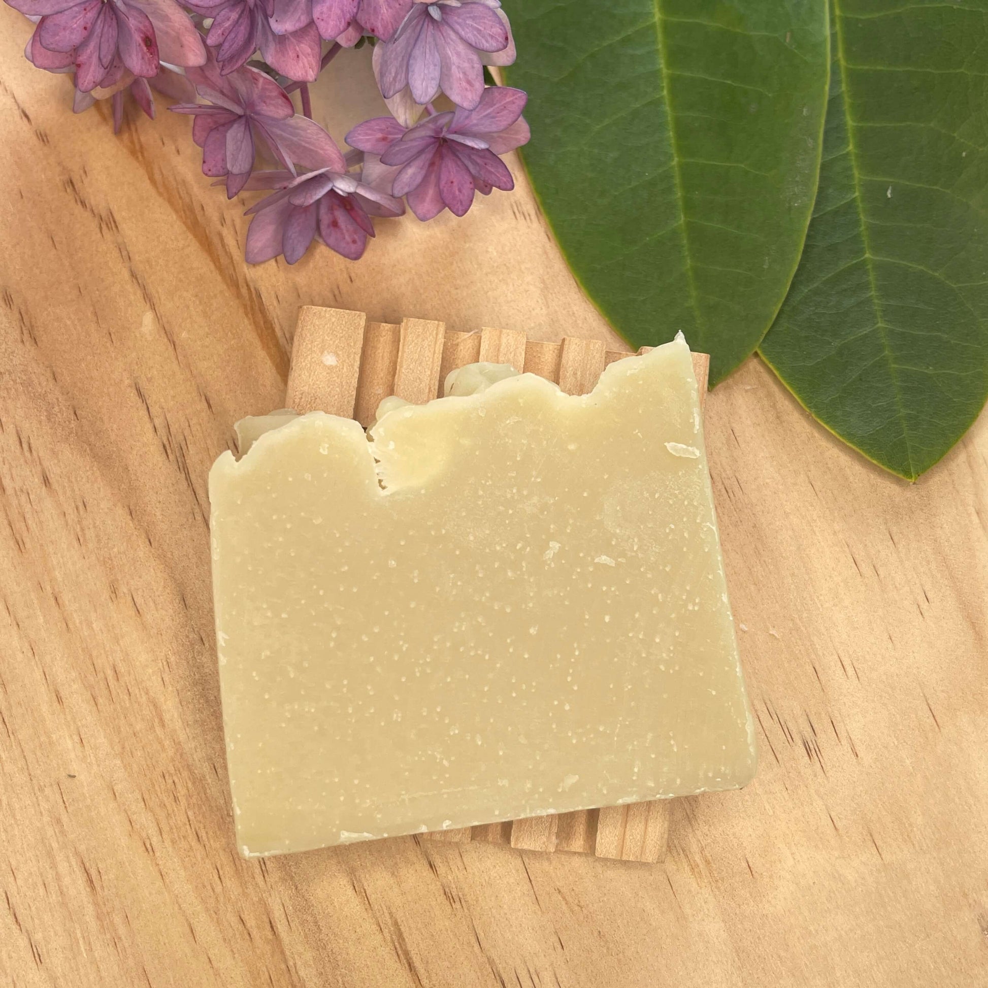 Natural shampoo bar on a wooden soap rack.