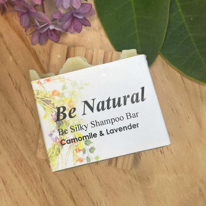 Natural shampoo bar on a wooden soap rack.