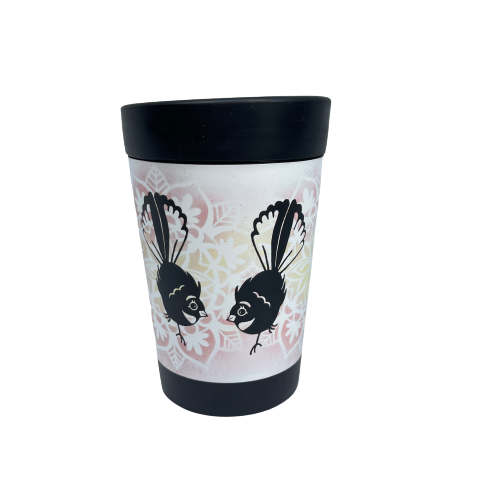 Black reusable coffee cup with white wrap and yellow & pink floral design featuring two cartoon style Fantail birds.