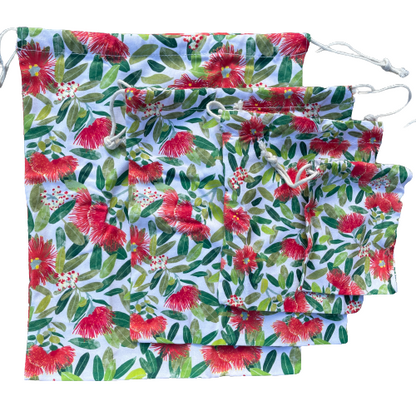 Four different sized drawstring bags in a Pohutukawa flower print.