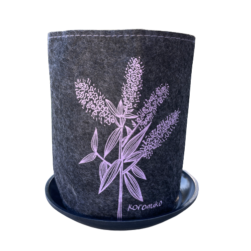 Dark grey felt planter with Koromiko flowers printed on it in purple, sitting in a grey dish.