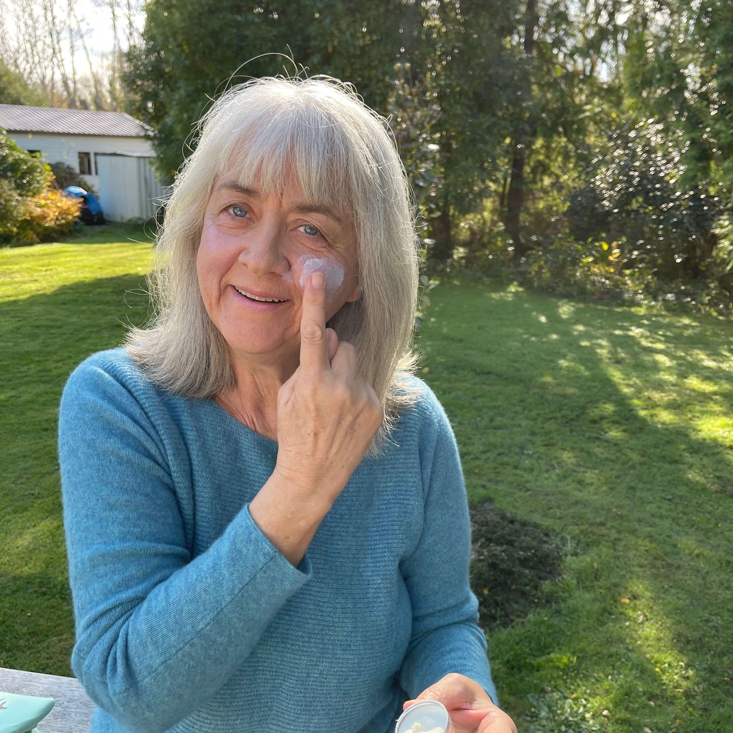 Woman applying a natural sun balm from the tin.