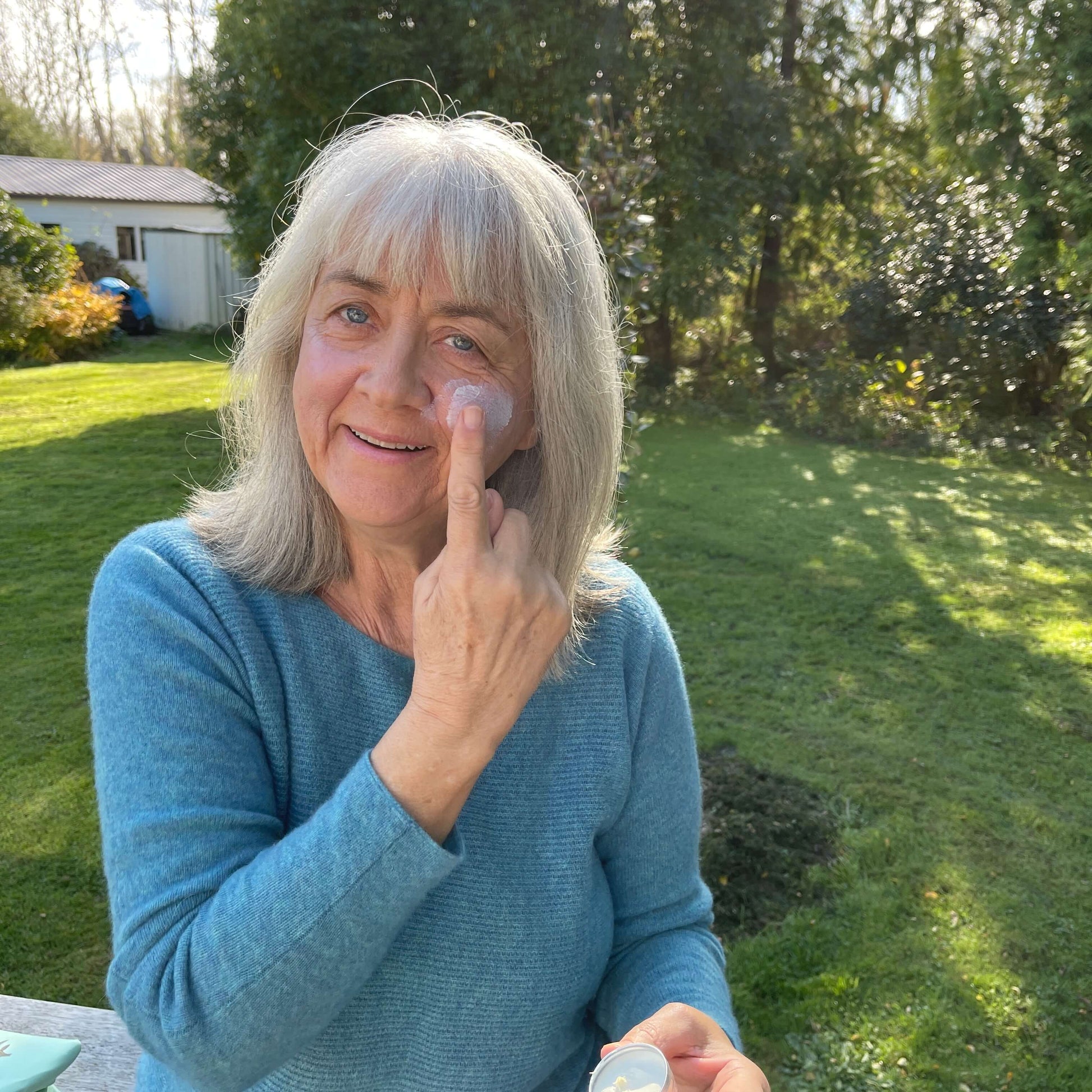 Woman applying a natural sun balm from the tin.