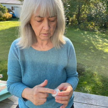 Woman applying a natural sun balm from the tin.