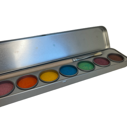 Watercolour paints in a tin with a paint brush.