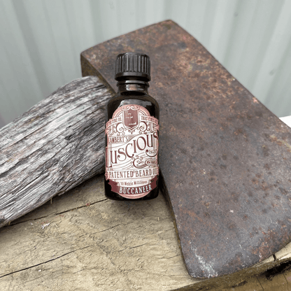 Small bottle of beard oil from Lamberts Luscious resting against an axe blade.