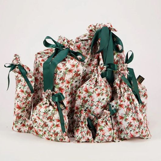 Reusable Christmas gift bags with a native NZ mistletoe print and tied with a green ribbon.