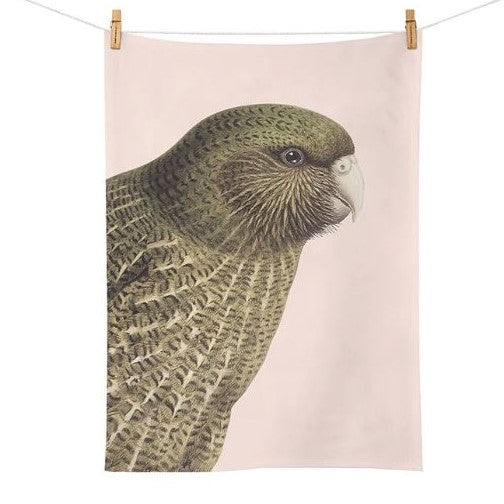 Pale pink tea towel with a Kakapo bird on it.