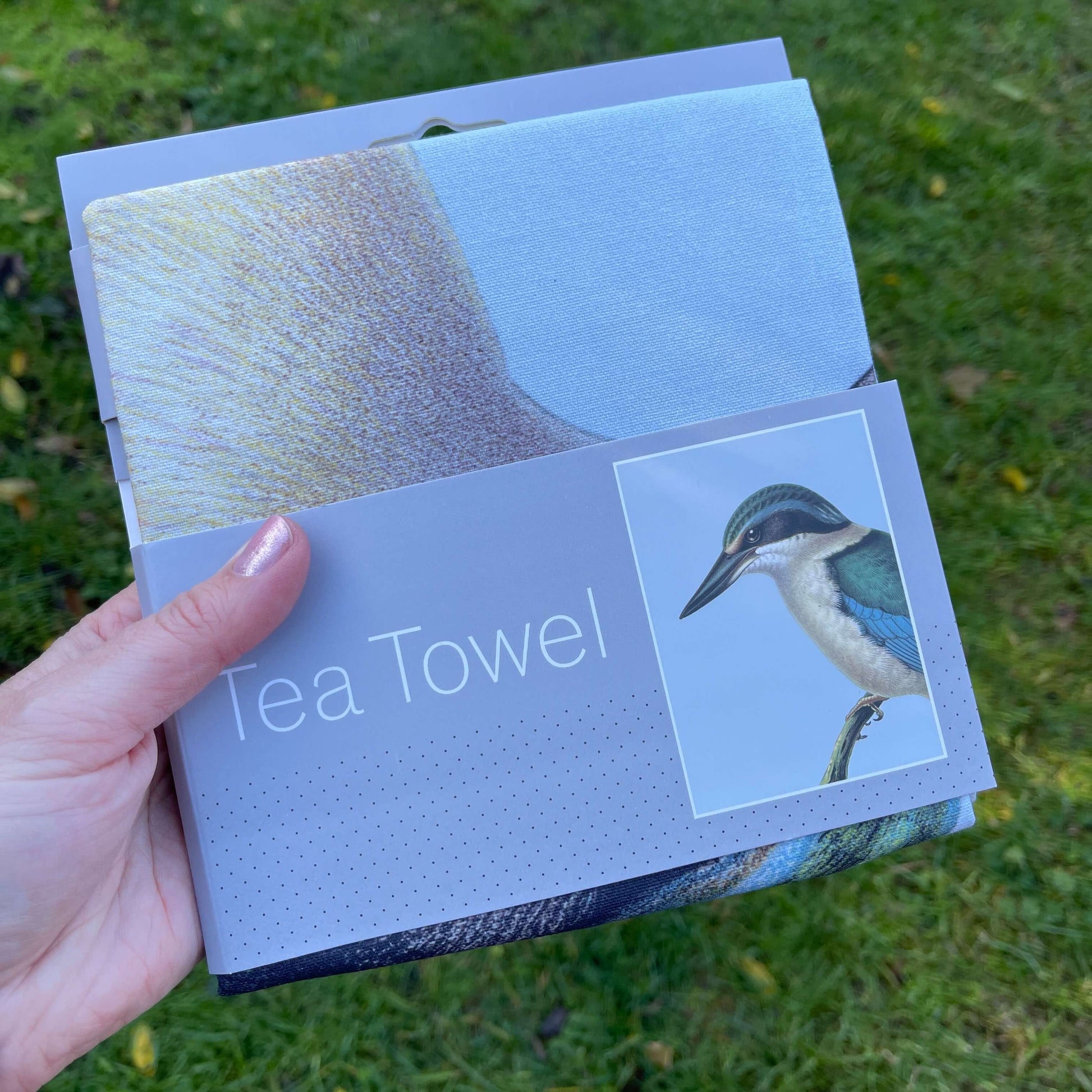 Pale blue tea towel with a Kingfisher bird on it.