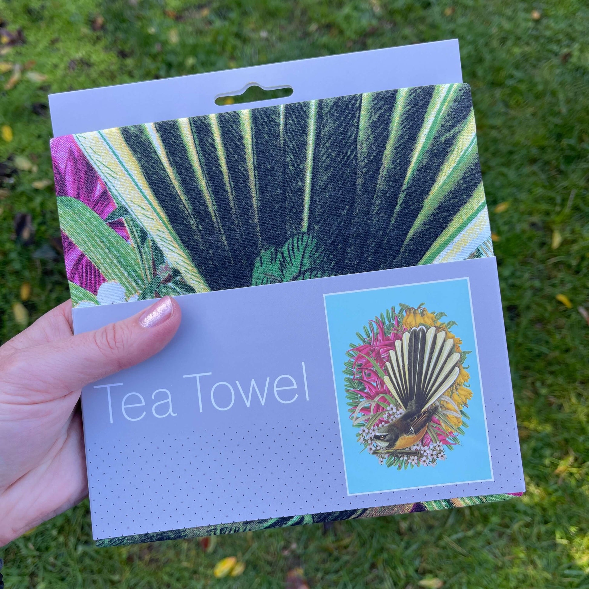 Tea towel with a Fantail and flowers on it.