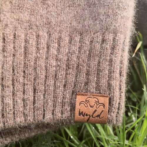 Close up of rib edge detail from a natural brown woolen jersey.